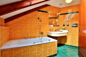 A bathroom with a bathtub, a sink, and a shower. - Hotel Carlton (Prague)