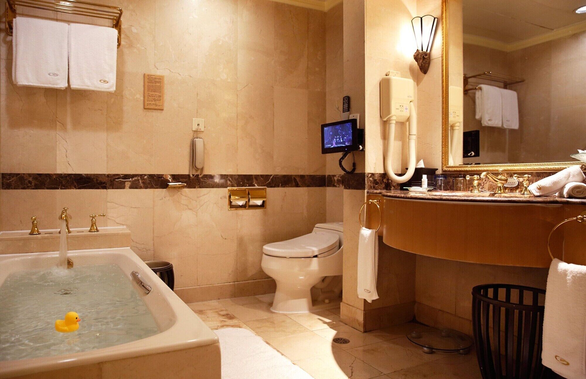 A bathroom with a bathtub, toilet, and sink.