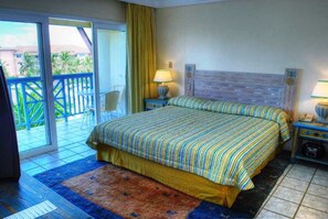 A hotel room with a bed, a nightstand, a lamp, a chair, and a view of the outdoors. - Sauipe Terra Resort - All Inclusive (Mata de São João)