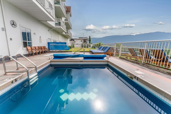 Alberca techada, alberca al aire libre y camastros