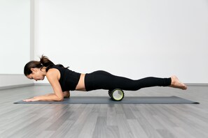 A person performing a yoga pose on a mat in a room with wooden flooring and white walls. - CIVANA Wellness Resort and Spa (Carefree)