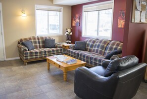 Relax in this cozy living space with two sofas, a leather armchair, and a coffee table.