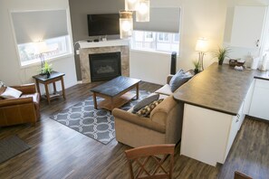Relax in a cozy living space with a comfortable seating area, fireplace, and kitchenette.