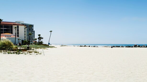 A beach with a hotel in the background. - Coronado Beach Resort (Coronado)