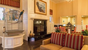 A spacious lobby with a fireplace, a birdcage, and a comfortable seating area. - Coronado Beach Resort (Coronado)