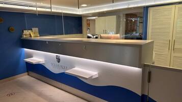 Un área de recepción con una decoración azul y blanca, un mostrador de recepción y una barra.