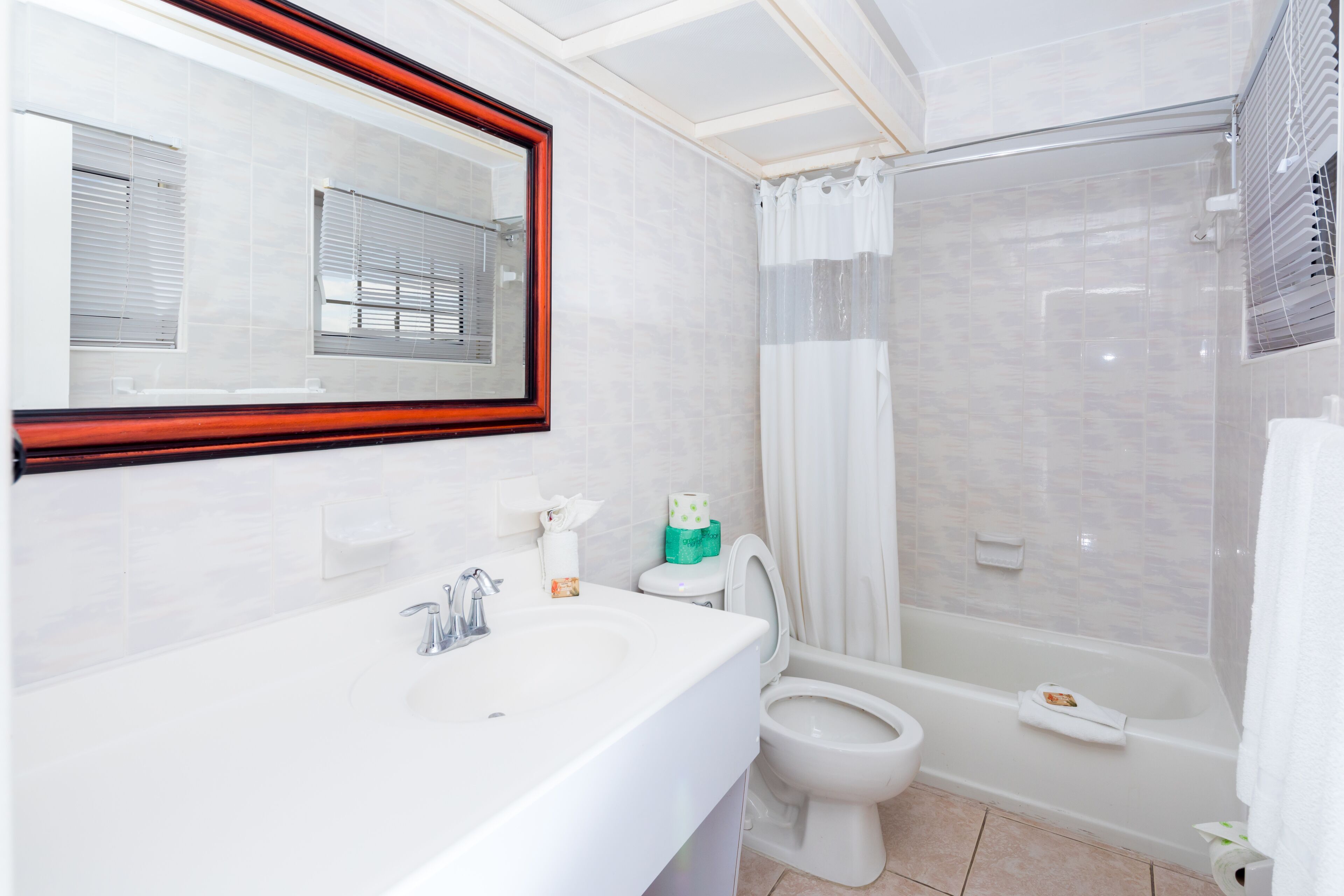 A modern bathroom with a white sink, toilet, and bathtub.