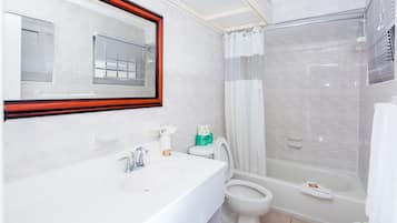 A modern bathroom with a white sink, toilet, and bathtub.