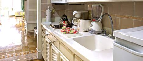 A kitchen with white cabinets, a microwave, a toaster, and a blender.