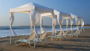 En privat strand, gratis strandhytter, liggestole, badehåndklæder