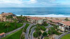 A coastal resort with multiple buildings, winding roads, and a beach view. - Pueblo Bonito Sunset Beach Golf & Spa Resort - All Inclusive (Cabo San Lucas)