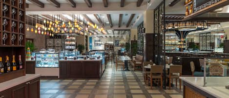 A restaurant with a checkered floor, wooden furniture, and hanging lights.
