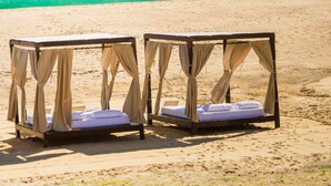Two canopy beds on a beach with a view of the ocean. - Pueblo Bonito Sunset Beach Golf & Spa Resort - All Inclusive (Cabo San Lucas)