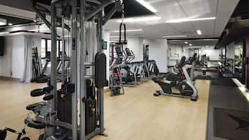 Una palestra con diverse attrezzature per esercizi, tra cui tapis roulant e macchinari per pesi.