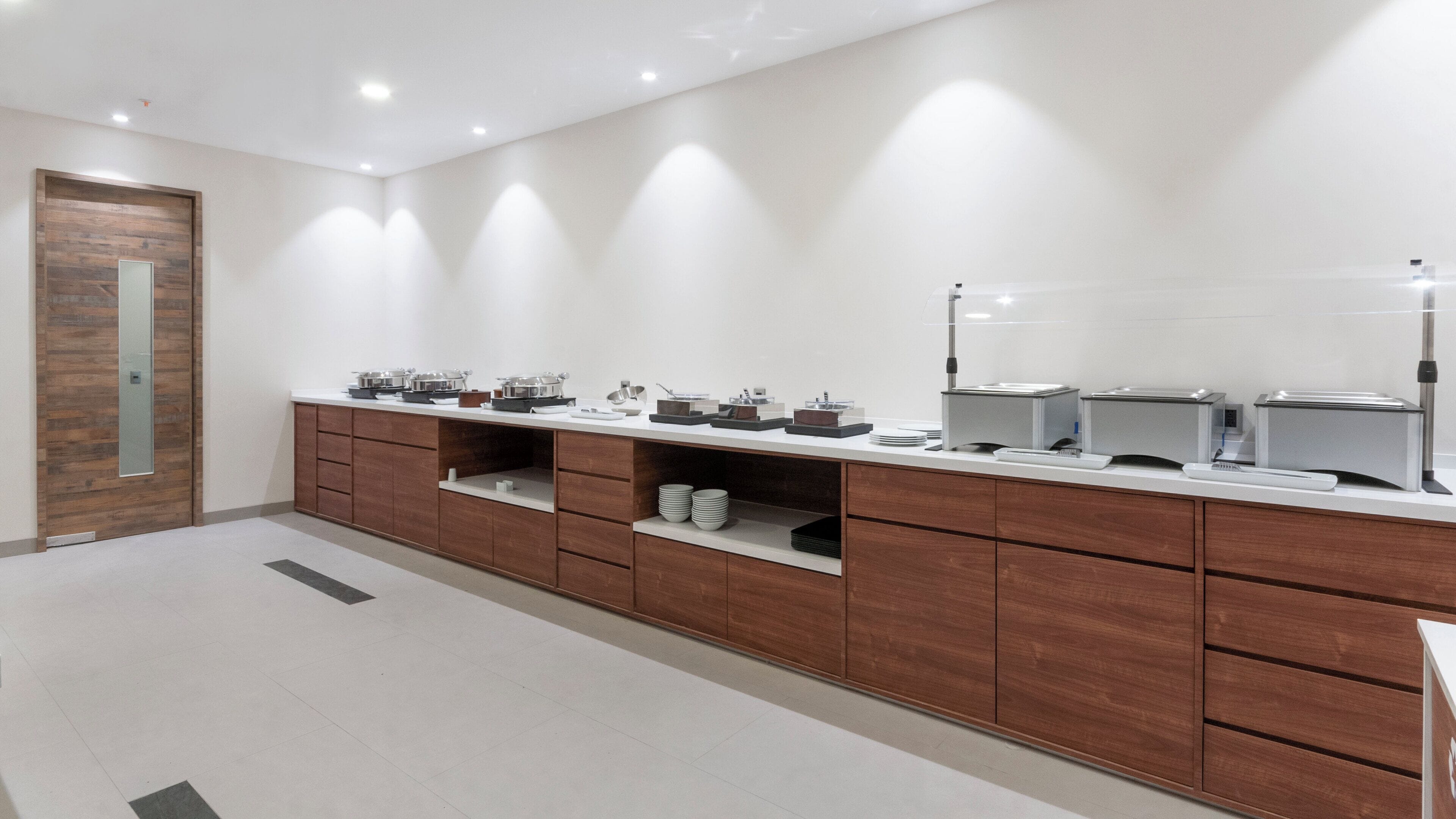 Une salle de bain moderne avec un meuble-lavabo en bois, un miroir et un plan de toilette sur lequel sont disposés divers produits de toilette et un évier.
