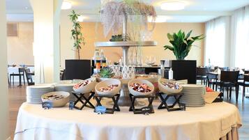 A buffet table with various food items and a decorative centerpiece.