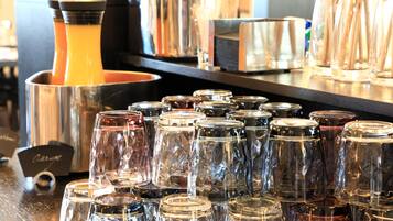 Zona de bar con distintos tipos de vasos, incluyendo varios vasos sencillos y una máquina de café.