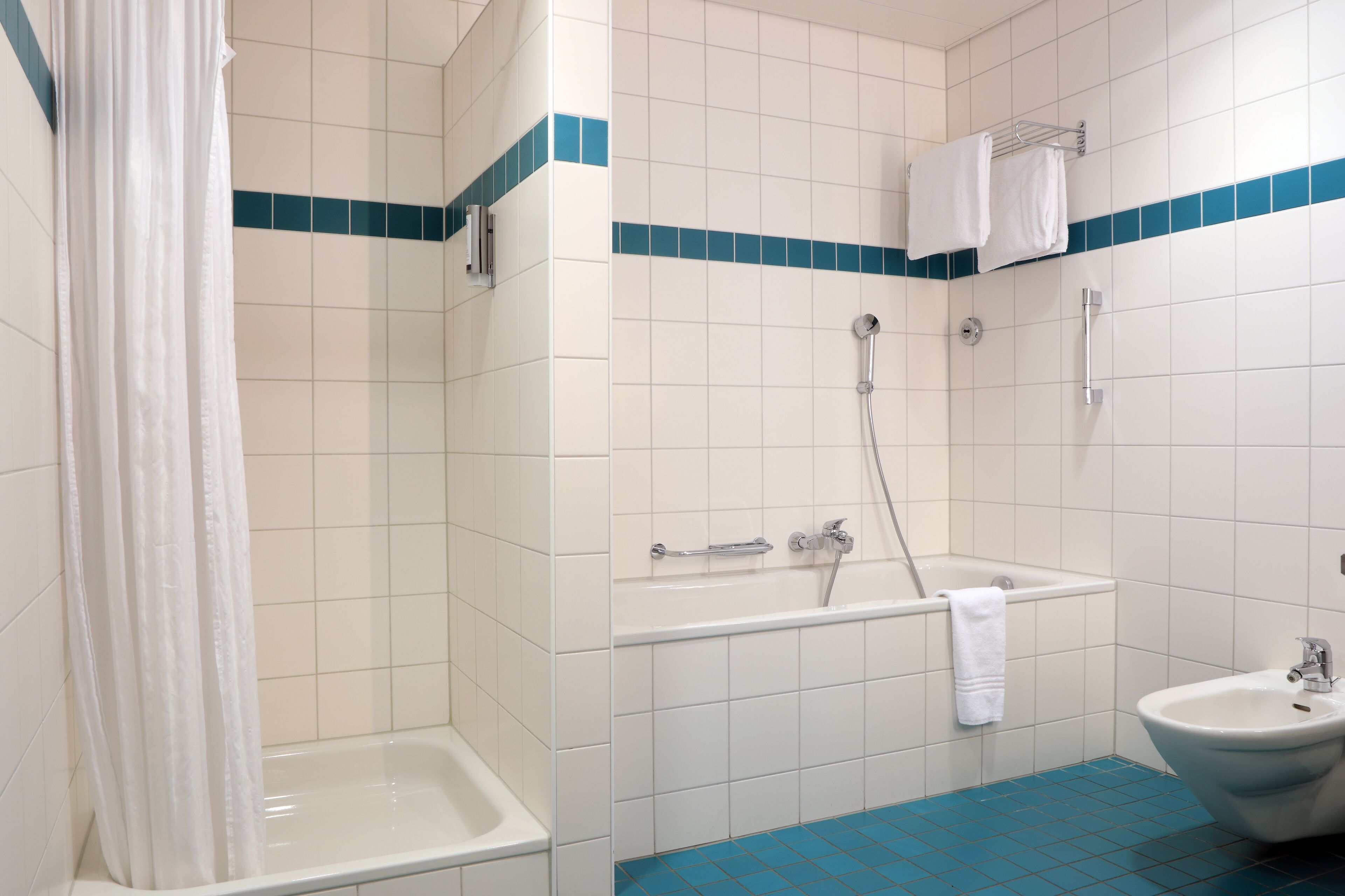 A bathroom with a shower, bathtub, and sink.