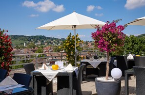 An outdoor dining area with tables, chairs, and umbrellas.