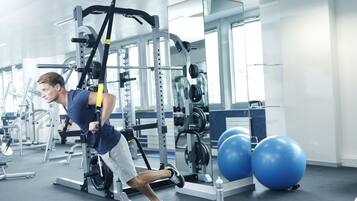A gym with exercise equipment, a weight rack, and large exercise balls.