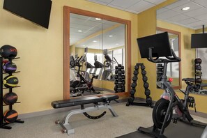 A gym with exercise equipment, a bench, and a mirrored wall. - Hilton Garden Inn Allentown Bethlehem Airport (Allentown)