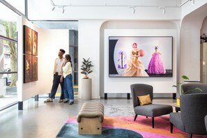 An art gallery with modern furniture, a large painting, and a view of the street outside. - Hotel Indigo Melbourne on Flinders by IHG (Melbourne)