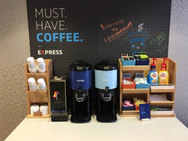 A coffee display with two coffee makers, a sign reading 'MUST. HAVE. COFFEE.', and various coffee-related products.