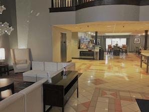 A hotel lobby with a reception desk, seating area, and a coffee bar. - Holiday Inn Express Hotel & Suites Laurinburg by IHG (Laurinburg)