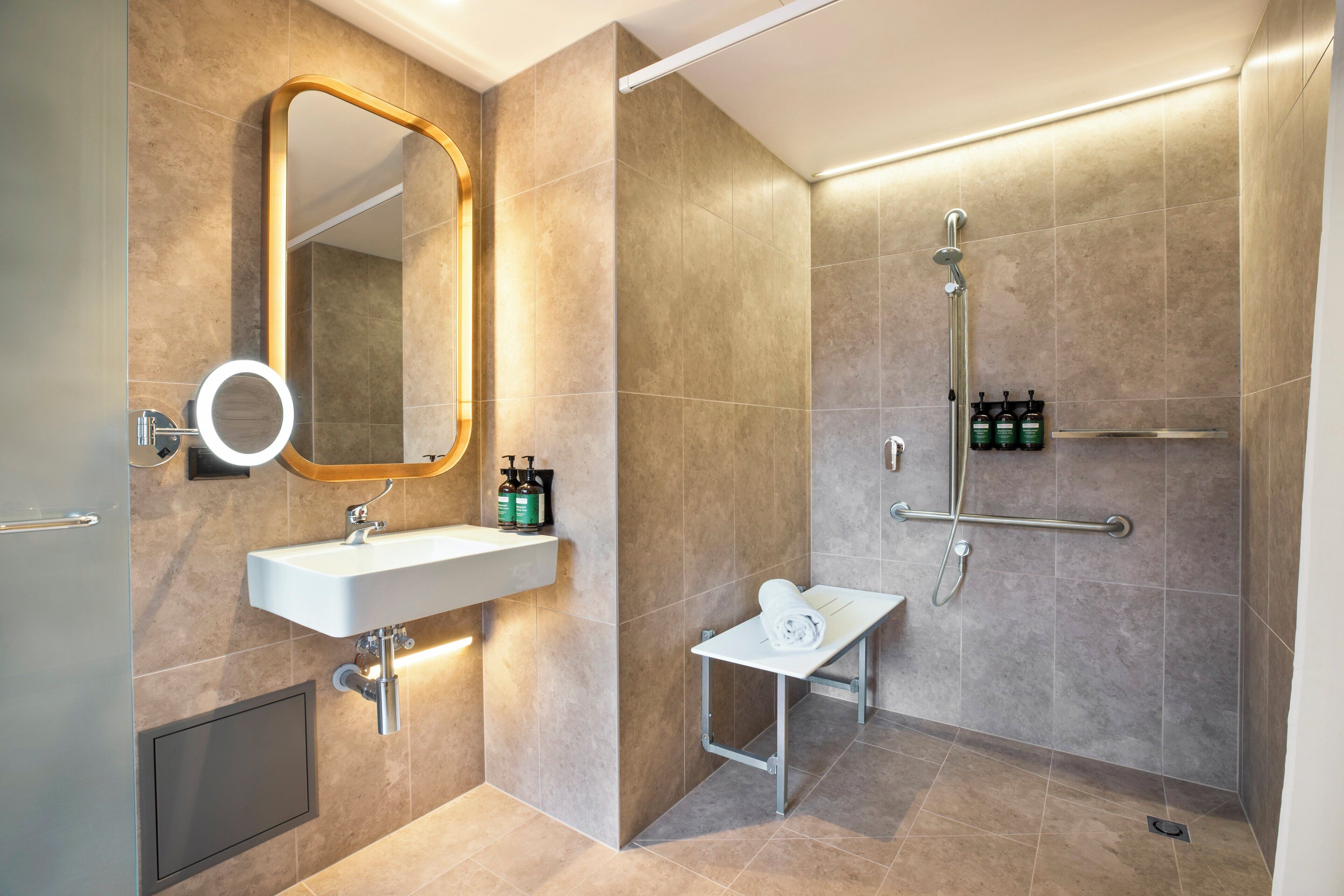 Ein modernes Badezimmer mit Waschbecken, Spiegel und Dusche.
