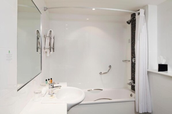 A modern bathroom with a white sink, mirror, and a walk-in shower.
