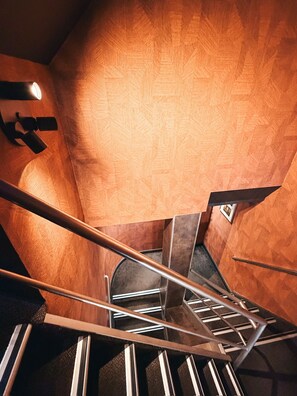 Una escalera con barandillas metálicas y un muro decorado.