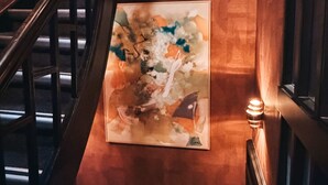 Una scala con corrimano e un quadro astratto appeso al muro.
