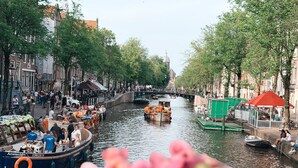 Un canale con barche, un ponte e palazzi lungo l'acqua.