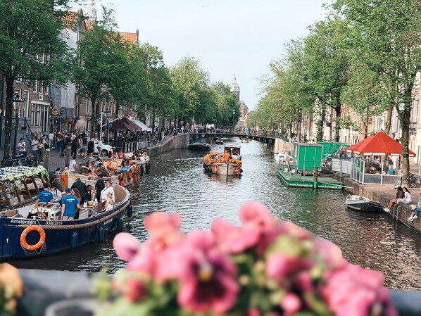 A canal with boats, a bridge, and buildings along the water. - Hotel Damsquare  (Amsterdam)