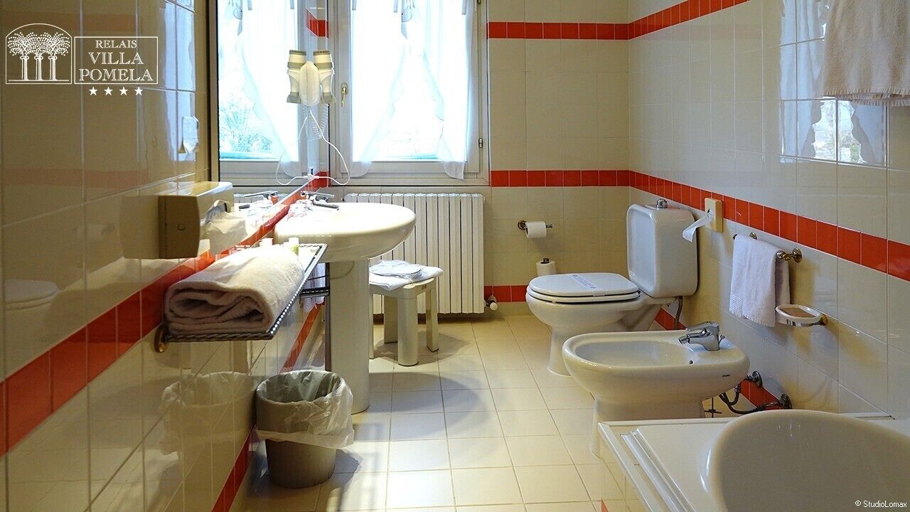 Un baño con inodoro, bidé, lavamanos y bañera.