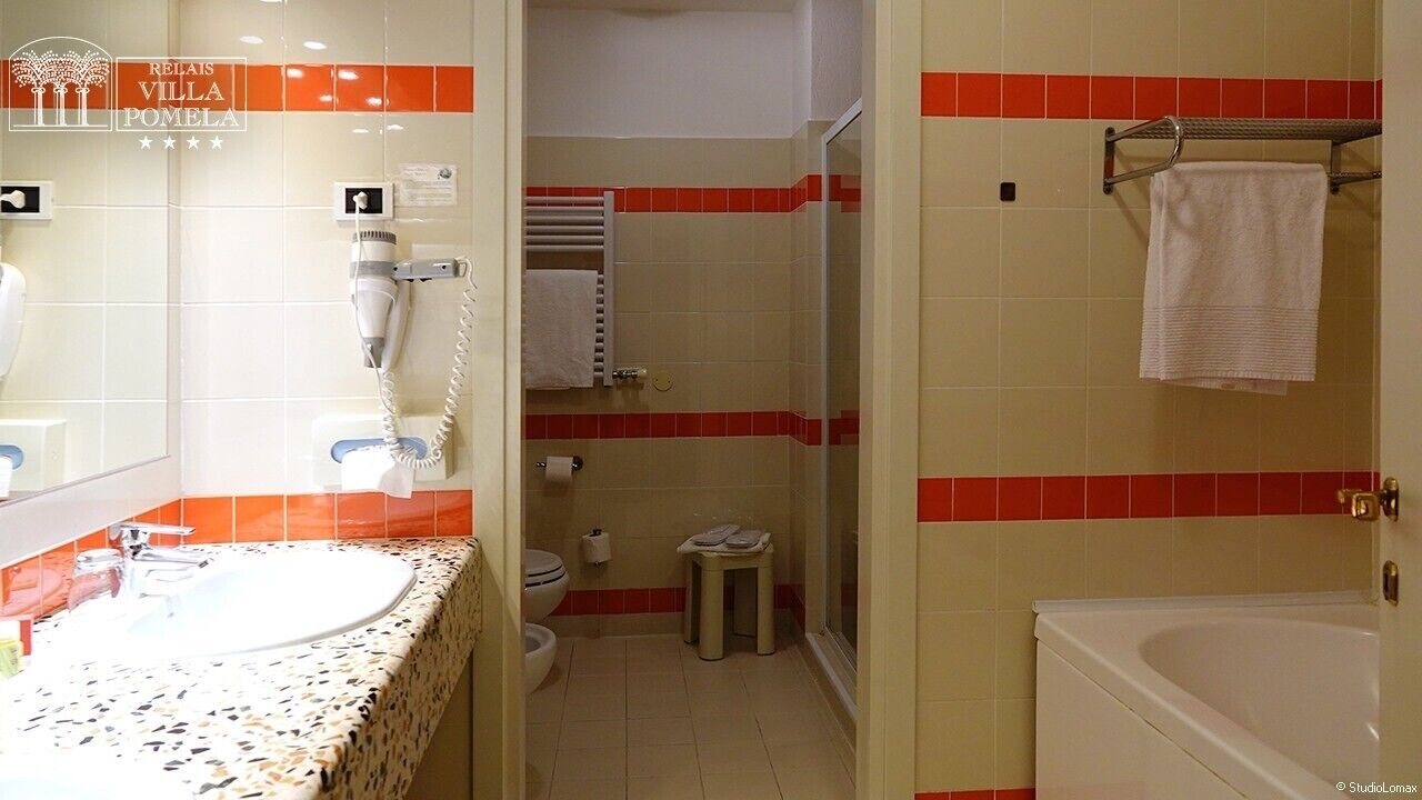 Une salle de bain équipée d’un lavabo, d’un sèche-cheveux et d’un porte-serviettes.