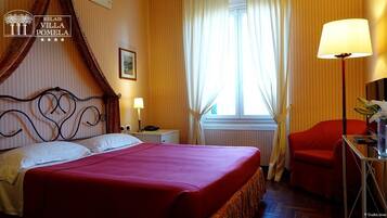 A hotel room with a bed, a nightstand, a lamp, a chair, and a window with curtains.