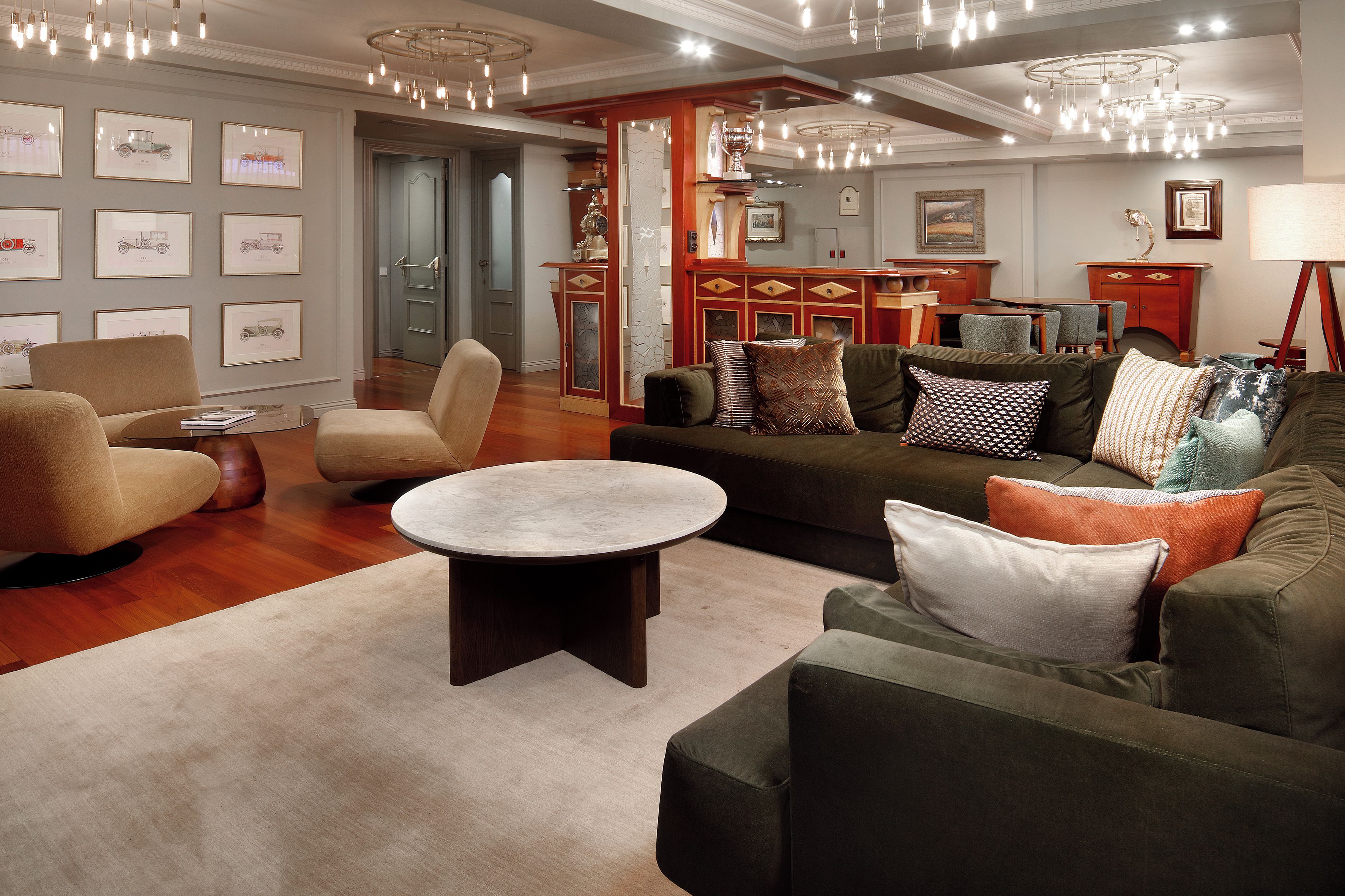 A modern living room with a round coffee table, sofas, and a fireplace.