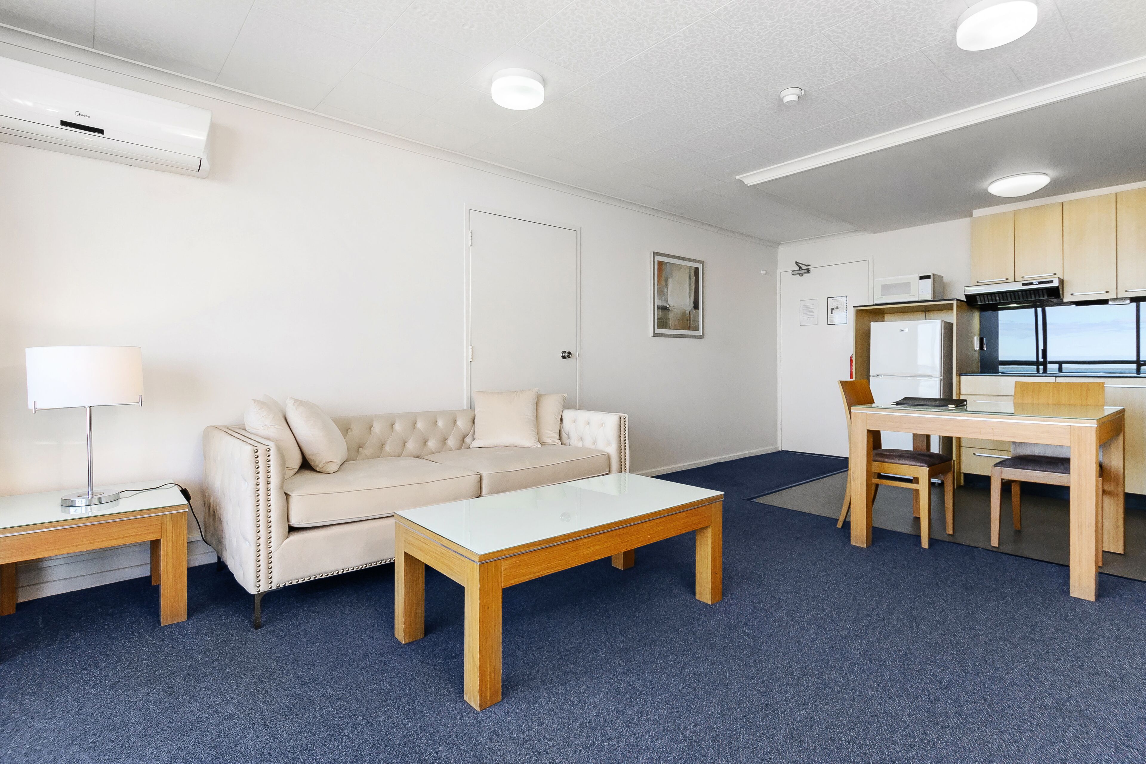 Una sala de estar moderna con un sofá, una mesa de centro y un comedor con una mesa y sillas.
