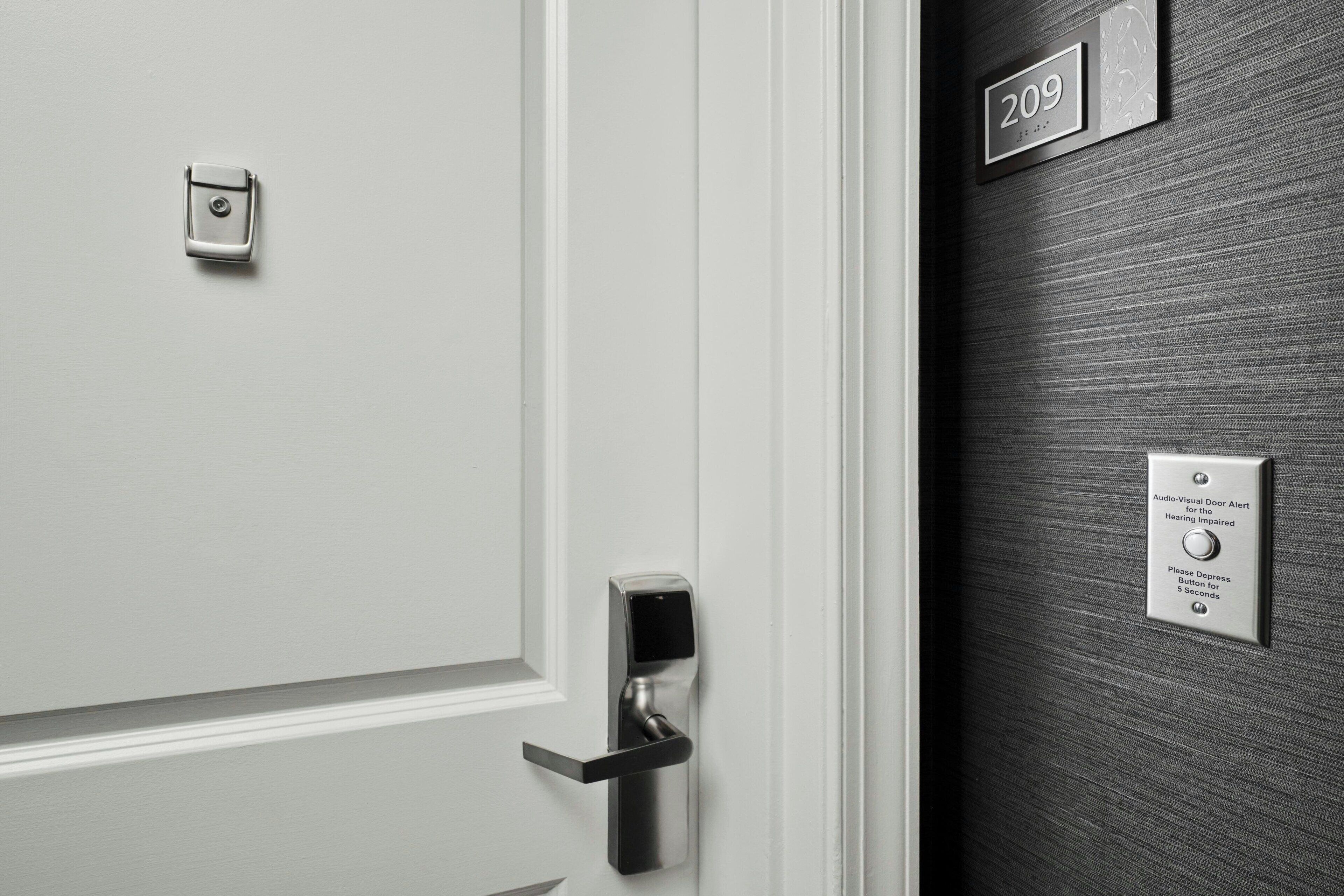 A door with a digital lock and a sign indicating the room number 209.