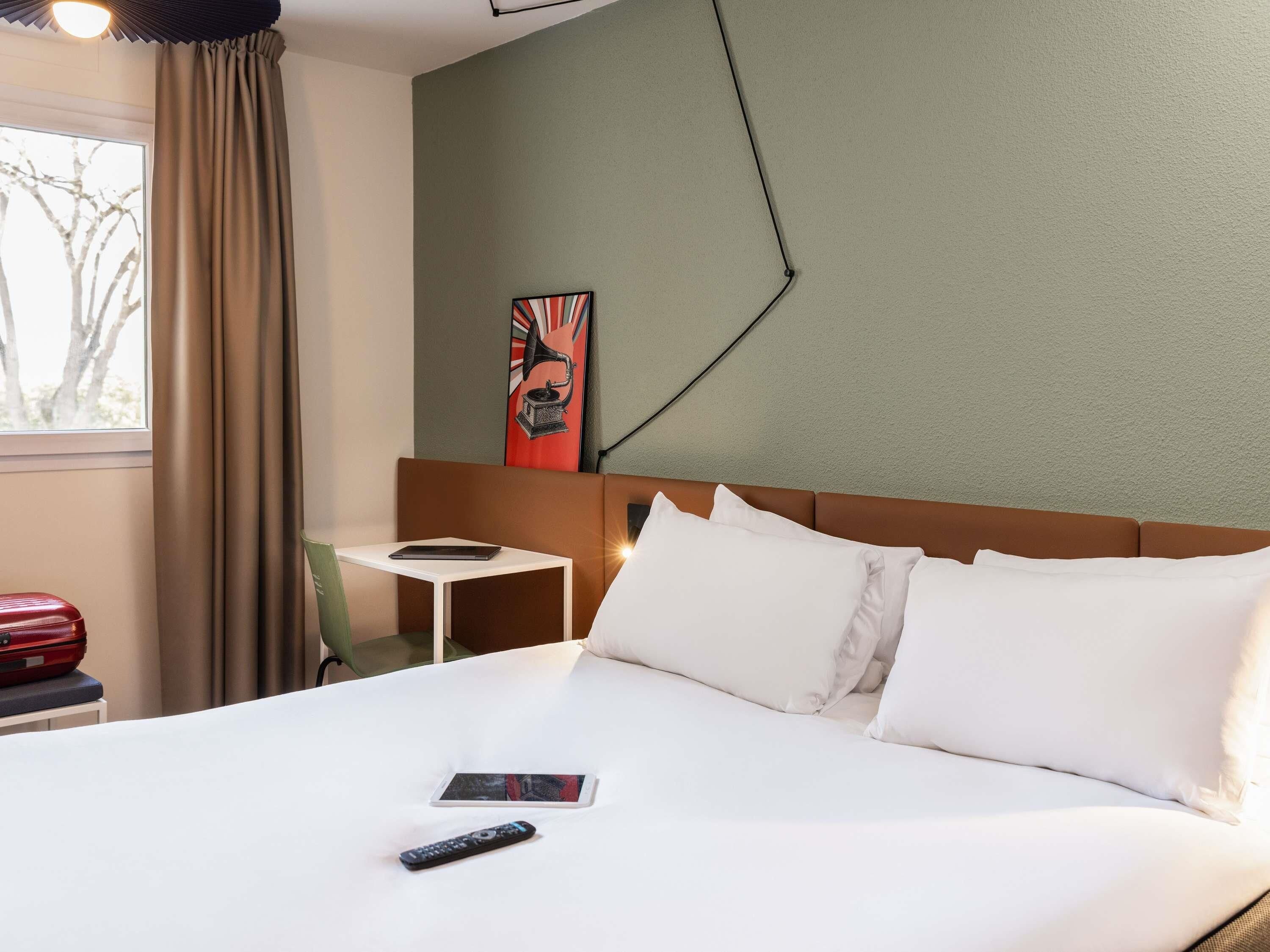 Een hotelkamer met een bed, een bureau en een stoel.