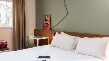 Een hotelkamer met een bed, een bureau en een stoel.