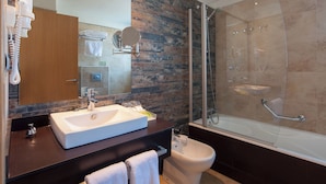 Un baño moderno con un lavamanos grande, un inodoro y una ducha con mampara de vidrio.