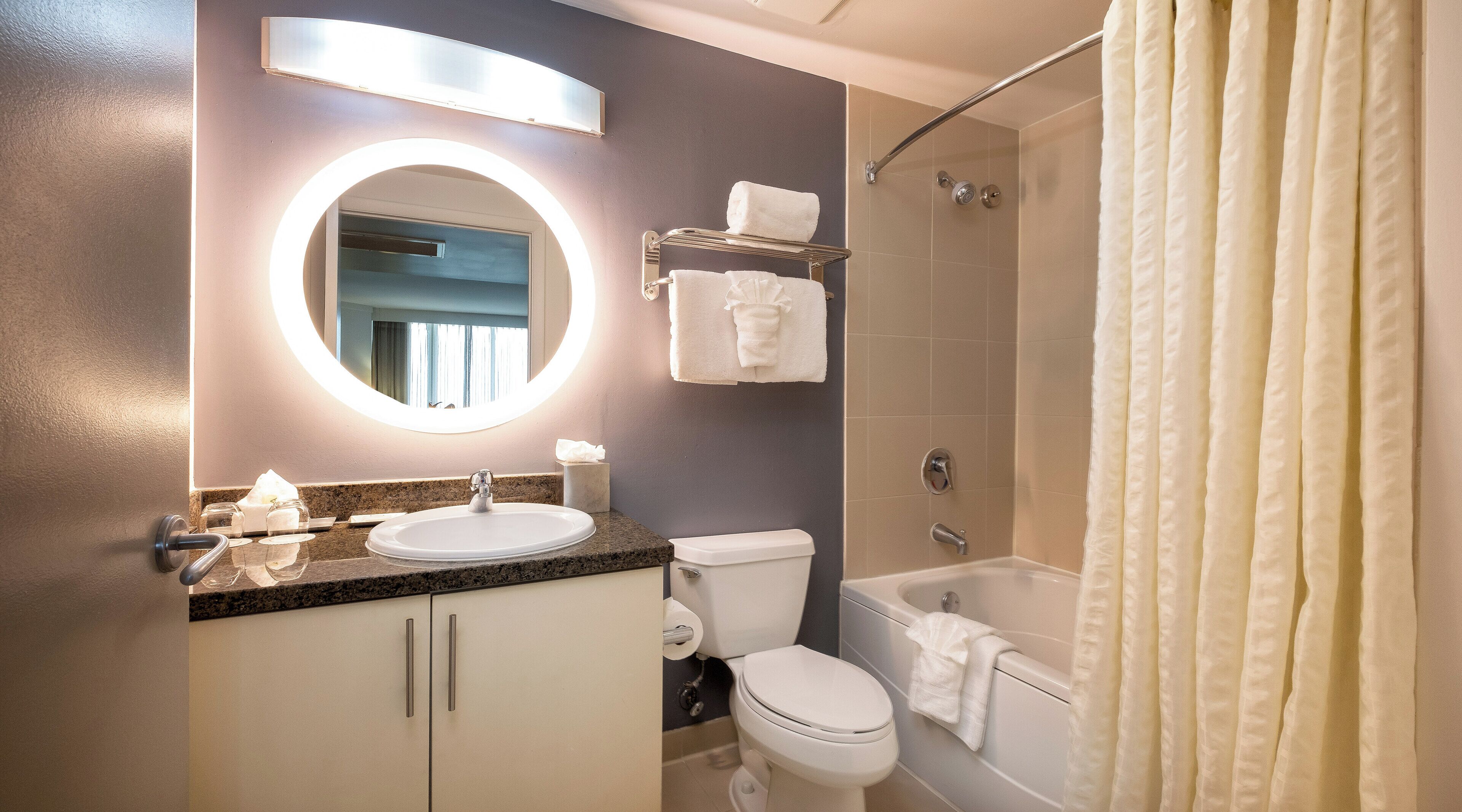 A modern bathroom with a sink, toilet, and bathtub.