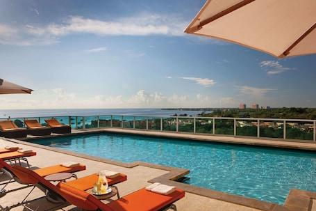 Una piscina al aire libre, camas de piscina gratis, sombrillas