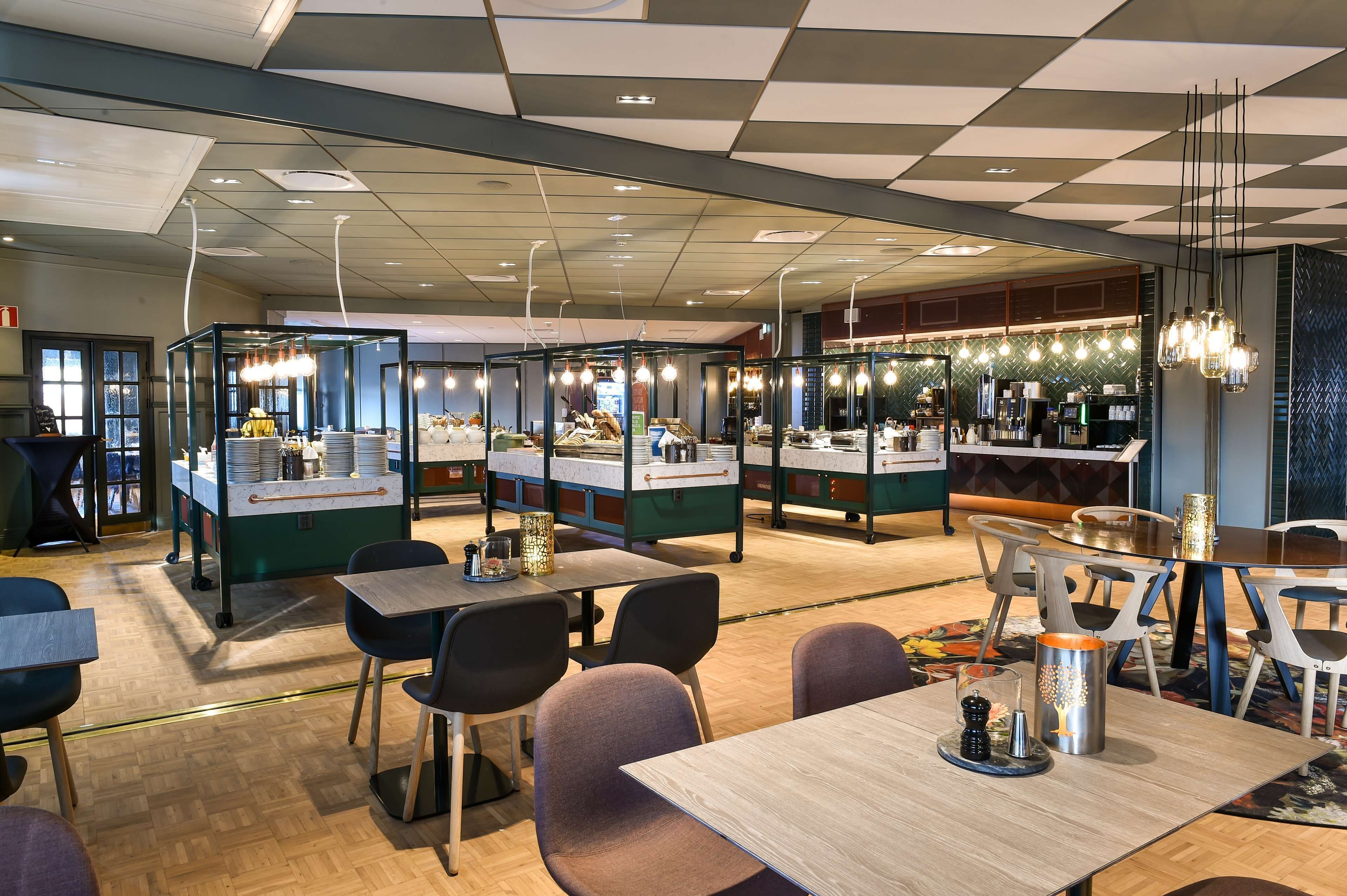 A modern restaurant with a checkered ceiling, multiple dining areas, and a bar.