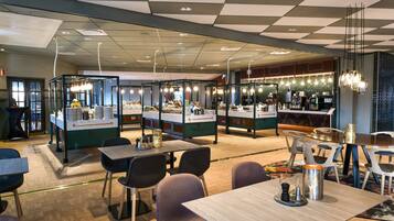 Een modern restaurant met een geruit plafond, meerdere eetgedeeltes en een bar.