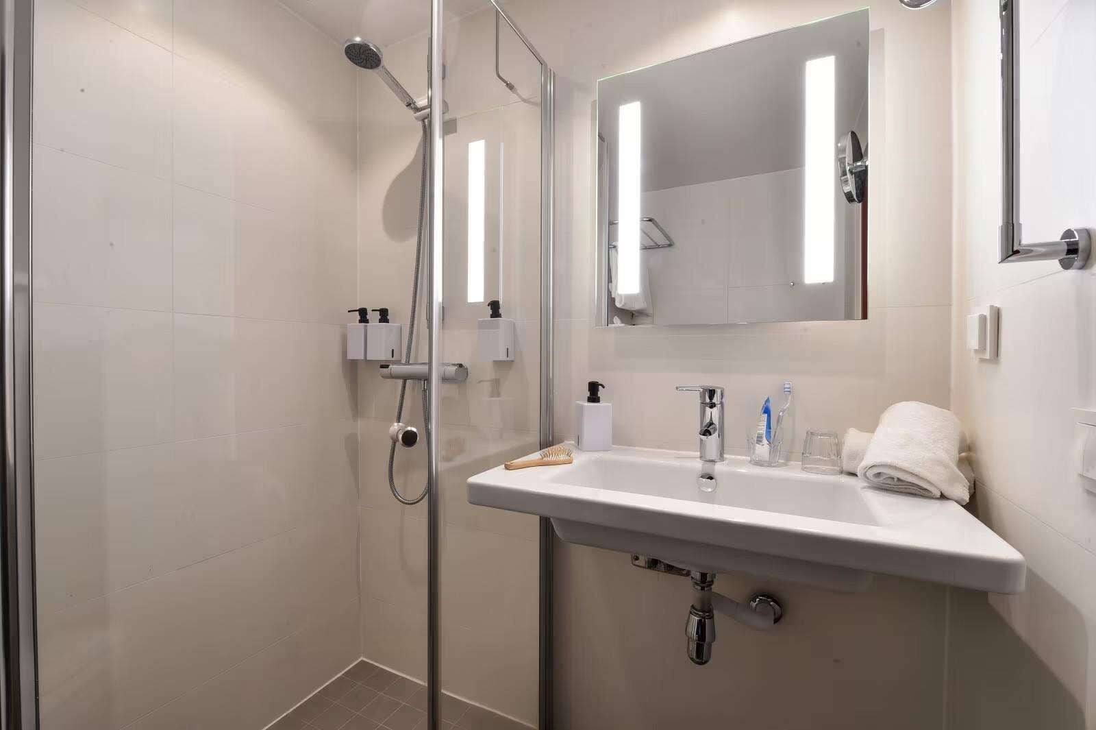standard twin room | bathroom | shower, hair dryer, towels