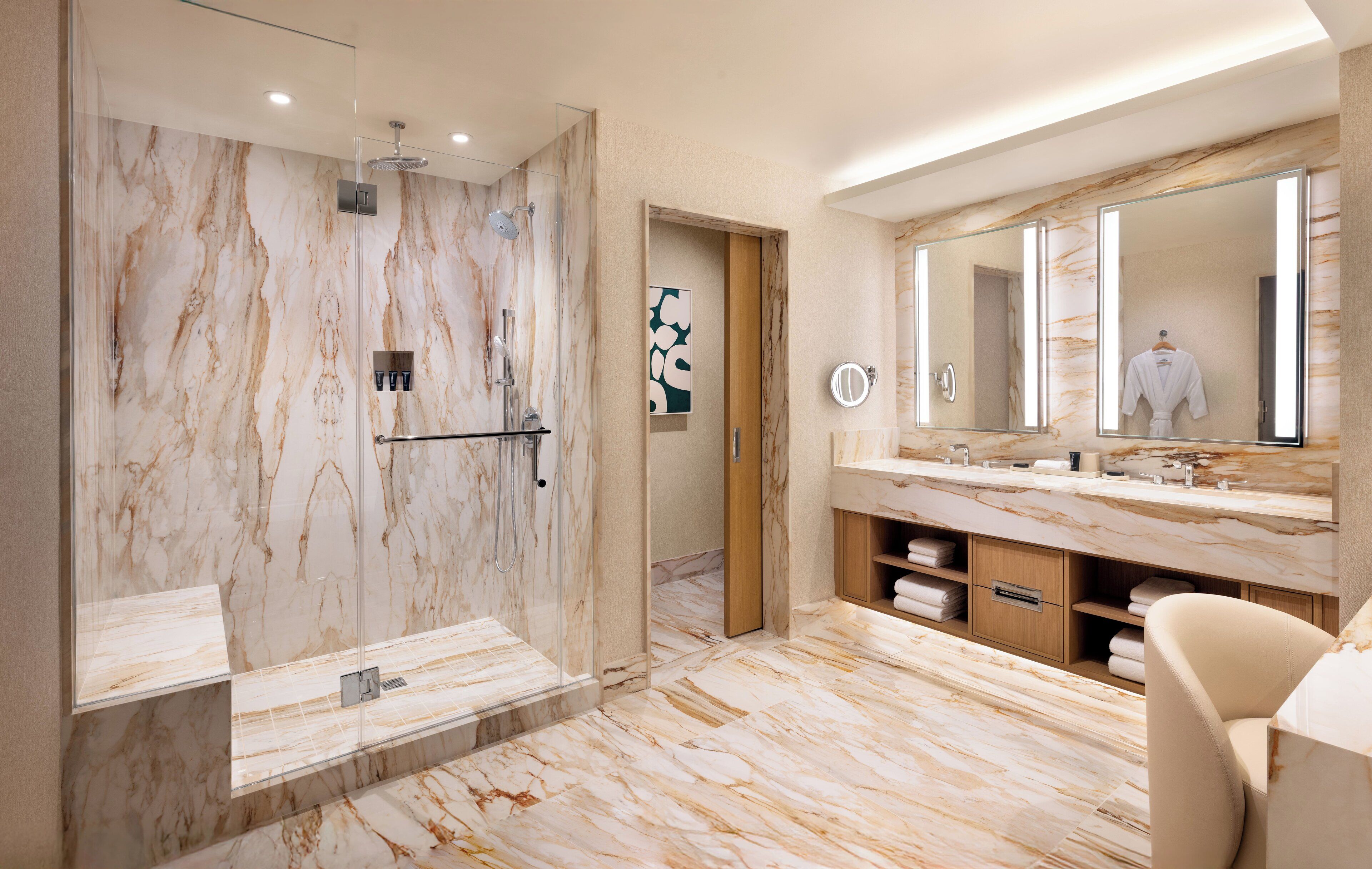 Een moderne badkamer met een marmeren douche, een grote spiegel en een wastafel met een handdoekhouder.