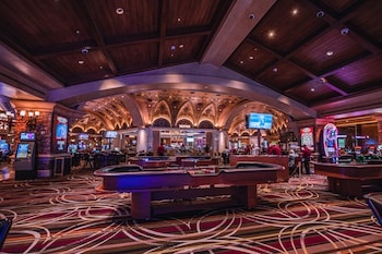 A luxurious bar area with a marble floor, elegant seating, and a chandelier. at Green Valley Ranch Resort and Spa